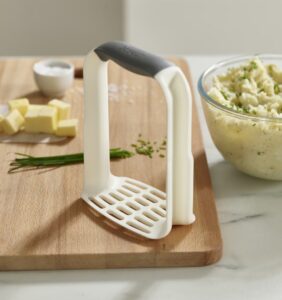 Ergonomic potato masher in white by Joseph Joseph with D-shaped handle and non-slip grip